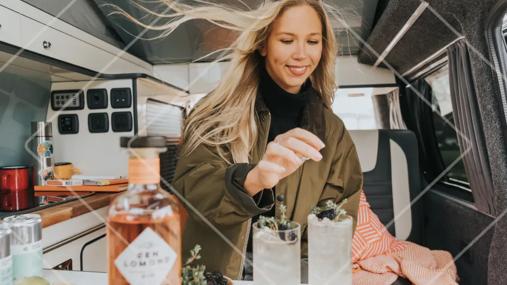 Rona serving her adventurous cocktail, "No Place Like Home," in a cozy campervan for her Ben Lomond Gin collaboration.