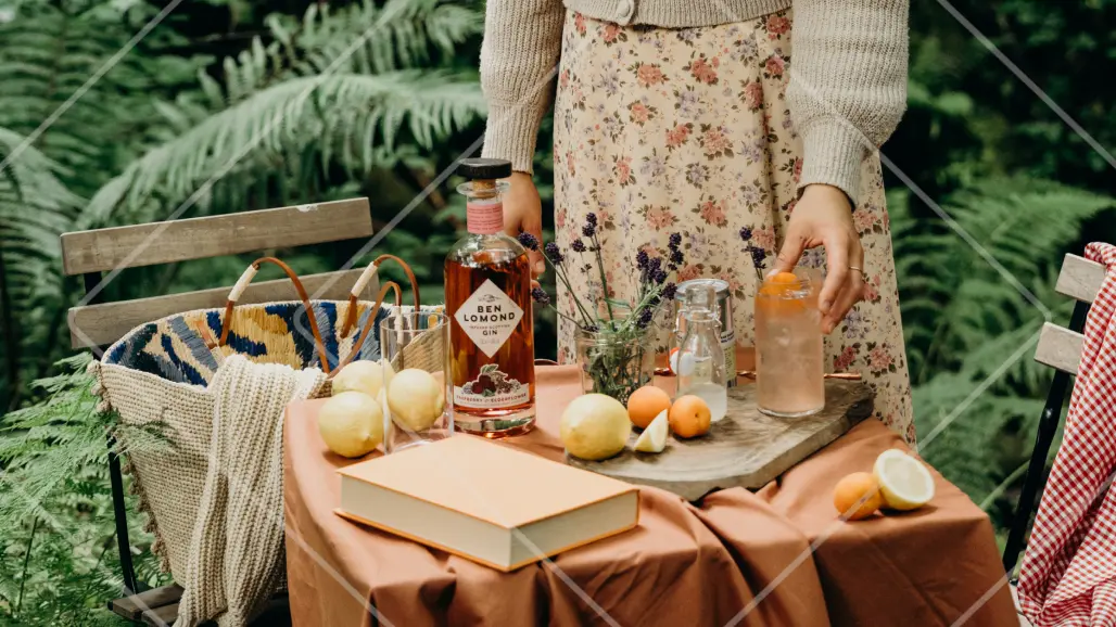 Table of ingredients for La Fleur Collins serve, including a bottle of Ben Lomond Raspberry & Elderflower Gin, in natural setting.