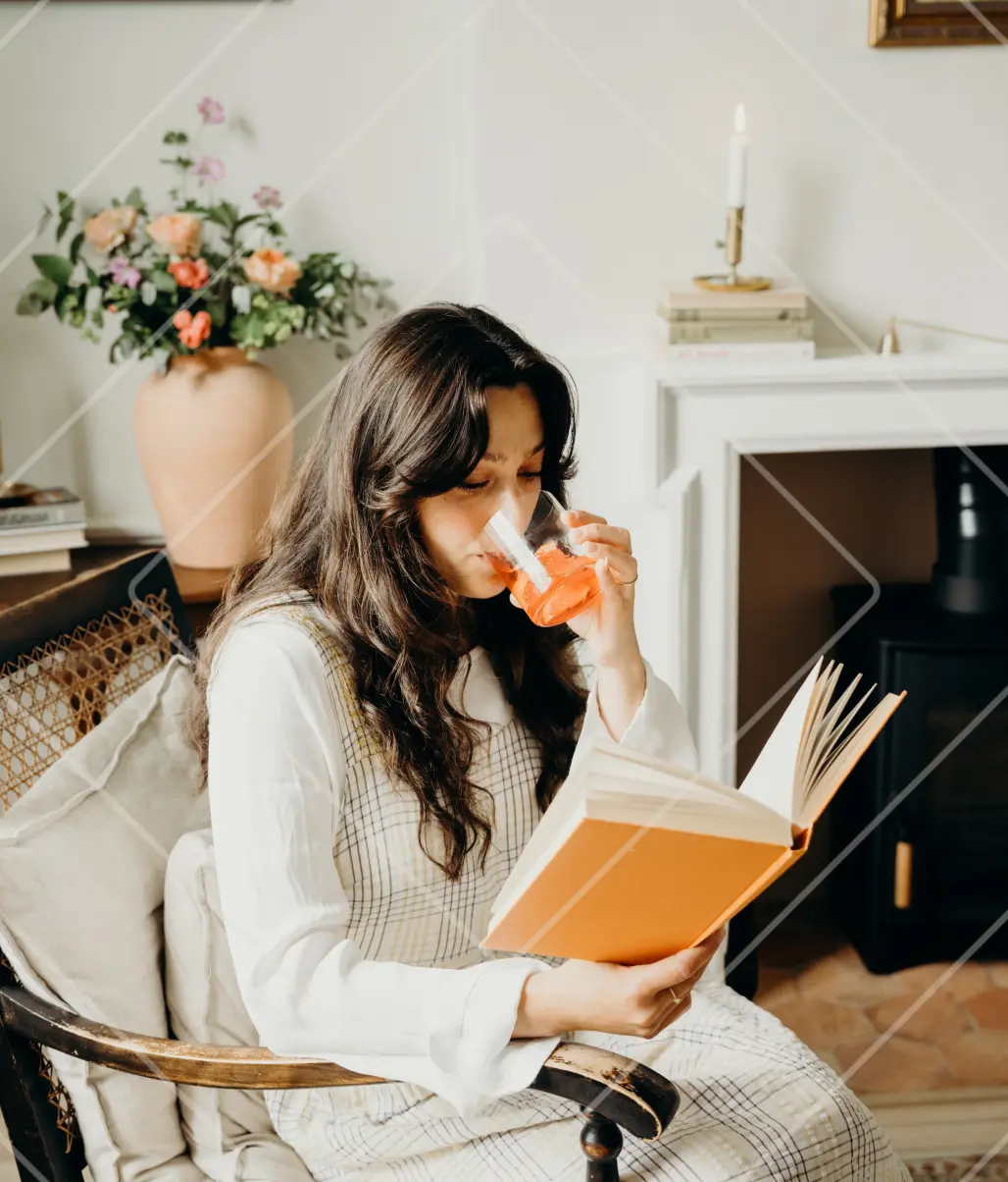 Patricia Rodi enjoying her Teracotta Negroni serve made with Ben Lomond Gin while reading a book by fire.